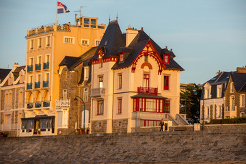: Beach in the evening sun and buildings along the seafront promenade in Saint Malo. Brittany, France
