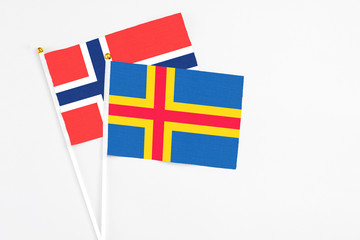 Aland Islands and Bouvet Islands stick flags on white background. High quality fabric, miniature national flag. Peaceful global concept.White floor for copy space.