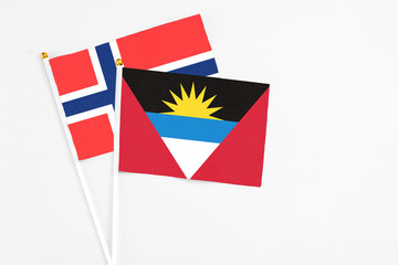 Antigua and Barbuda and Bouvet Islands stick flags on white background. High quality fabric, miniature national flag. Peaceful global concept.White floor for copy space.