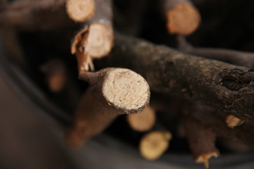 brushwood in a bucket for a stove or fireplace near a brick wall. Old firewood basket on a rustic wooden floor