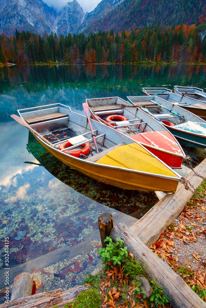 Wall mural alpine lake and colorful boats, lake fusine,italy