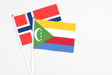 Comoros and Bouvet Islands stick flags on white background. High quality fabric, miniature national flag. Peaceful global concept.White floor for copy space.