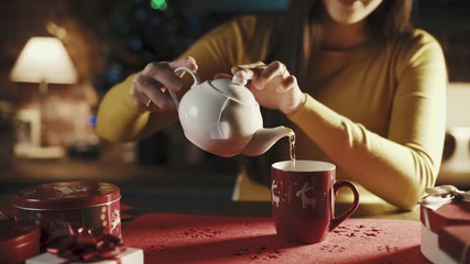 Woman pouring tea in a holiday cup