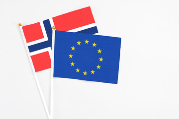 European Union and Bouvet Islands stick flags on white background. High quality fabric, miniature national flag. Peaceful global concept.White floor for copy space.