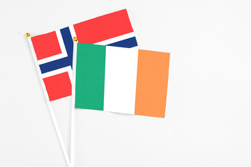 Fototapeta na wymiar Ireland and Bouvet Islands stick flags on white background. High quality fabric, miniature national flag. Peaceful global concept.White floor for copy space.