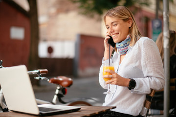 Beautiful businesswoman in cafe. Young woman responding on email while sitting in cafe.