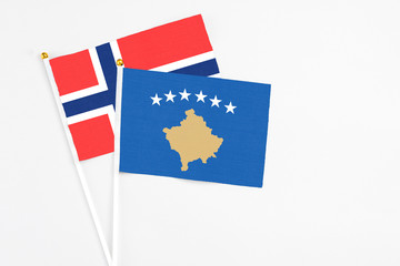 Kosovo and Bouvet Islands stick flags on white background. High quality fabric, miniature national flag. Peaceful global concept.White floor for copy space.