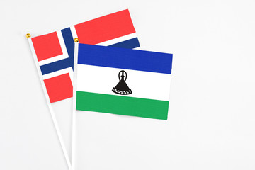 Lesotho and Bouvet Islands stick flags on white background. High quality fabric, miniature national flag. Peaceful global concept.White floor for copy space.