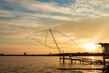 Fototapeta na wymiar Fisherman's Fishing Tools In the lake at sunset sky background.