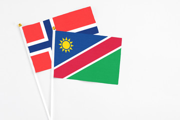 Namibia and Bouvet Islands stick flags on white background. High quality fabric, miniature national flag. Peaceful global concept.White floor for copy space.