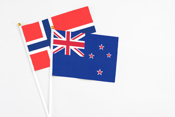 Fototapeta premium New Zealand and Bouvet Islands stick flags on white background. High quality fabric, miniature national flag. Peaceful global concept.White floor for copy space.