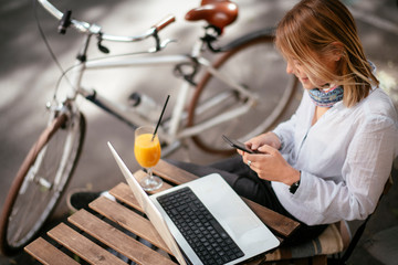 Young woman in cafe. Beautiful woman sitting in cafe and using phone.