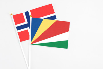 Seychelles and Bouvet Islands stick flags on white background. High quality fabric, miniature national flag. Peaceful global concept.White floor for copy space.