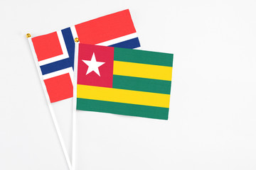 Togo and Bouvet Islands stick flags on white background. High quality fabric, miniature national flag. Peaceful global concept.White floor for copy space.