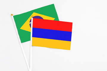 Armenia and Brazil stick flags on white background. High quality fabric, miniature national flag. Peaceful global concept.White floor for copy space.