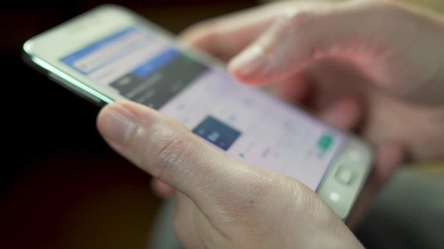 Close-up of hands and smartphone. Man looking for plane tickets using the online application in the smartphone cell phone to the Internet by touching the screen. 