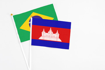 Cambodia and Brazil stick flags on white background. High quality fabric, miniature national flag. Peaceful global concept.White floor for copy space.