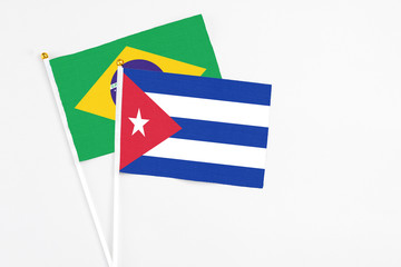 Cuba and Brazil stick flags on white background. High quality fabric, miniature national flag. Peaceful global concept.White floor for copy space.
