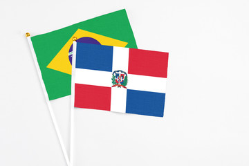 Dominican Republic and Brazil stick flags on white background. High quality fabric, miniature national flag. Peaceful global concept.White floor for copy space.