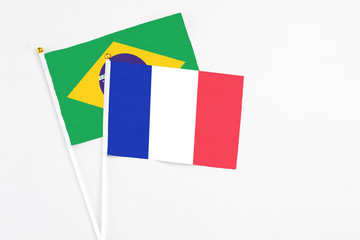 France and Brazil stick flags on white background. High quality fabric, miniature national flag. Peaceful global concept.White floor for copy space.