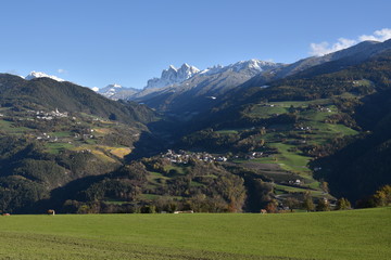 Fototapeta premium View of mountain village in Dolomites with meadow in front