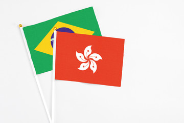 Hong Kong and Brazil stick flags on white background. High quality fabric, miniature national flag. Peaceful global concept.White floor for copy space.