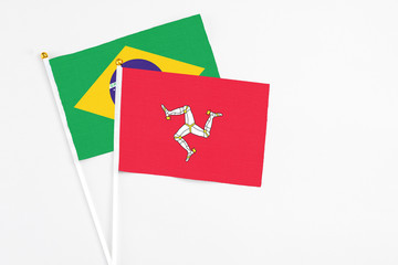Isle Of Man and Brazil stick flags on white background. High quality fabric, miniature national flag. Peaceful global concept.White floor for copy space.