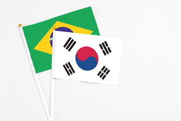 South Korea and Brazil stick flags on white background. High quality fabric, miniature national flag. Peaceful global concept.White floor for copy space.