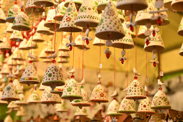 Florence, ITALY - DECEMBER 2018: small decorated bells hanging from the roof at the Christmas market in front of the 'Basilica of Santa Croce'. Christmas