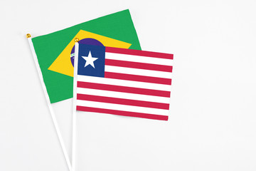 Liberia and Brazil stick flags on white background. High quality fabric, miniature national flag. Peaceful global concept.White floor for copy space.