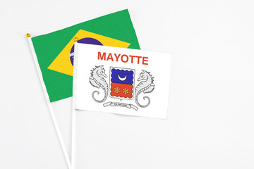 Mayotte and Brazil stick flags on white background. High quality fabric, miniature national flag. Peaceful global concept.White floor for copy space.