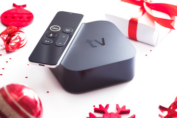 Set of controller and micro console for TV watching and online streaming. Red Christmas toys on the...