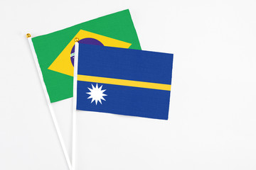 Nauru and Brazil stick flags on white background. High quality fabric, miniature national flag. Peaceful global concept.White floor for copy space.