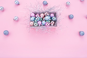 Christmas composition. Christmas balls, pink and blue decorations on pink background. Christmas gift box with Christmas balls. Flat lay, copy space, top view. Winter holidays, New Year. 