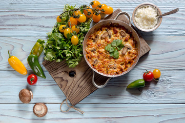 Pieces of chicken breast baked with mushrooms and cheese close-up.