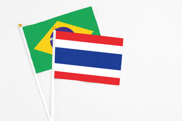Thailand and Brazil stick flags on white background. High quality fabric, miniature national flag. Peaceful global concept.White floor for copy space.