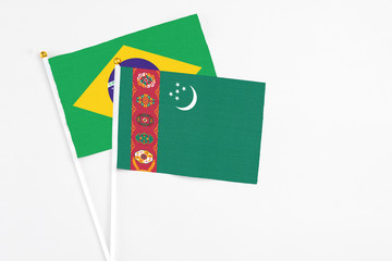 Turkmenistan and Brazil stick flags on white background. High quality fabric, miniature national flag. Peaceful global concept.White floor for copy space.