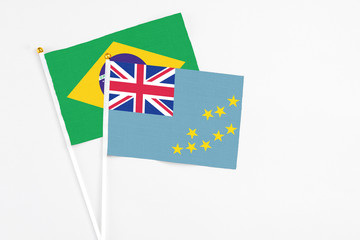 Fototapeta premium Tuvalu and Brazil stick flags on white background. High quality fabric, miniature national flag. Peaceful global concept.White floor for copy space.