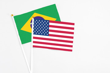 United States and Brazil stick flags on white background. High quality fabric, miniature national flag. Peaceful global concept.White floor for copy space.