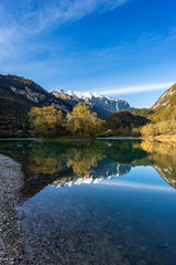 Naklejka na ściany i meble Lago di Tenno in autumn, small beautiful lake with reflections in Italian alps, Trento province, Trentino-Alto Adige, Italy, Europe