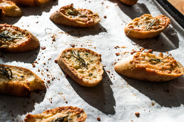 Garlic Parmesan Cheese Bread Slices on Baking Paper Sheet with Oven Tray. Freshly Baked.