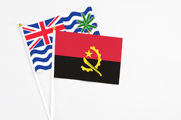 Angola and British Indian Ocean Territory stick flags on white background. High quality fabric, miniature national flag. Peaceful global concept.White floor for copy space.