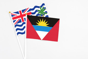 Antigua and Barbuda and British Indian Ocean Territory stick flags on white background. High quality fabric, miniature national flag. Peaceful global concept.White floor for copy space.
