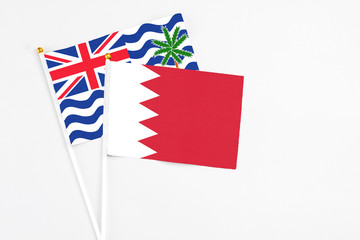 Bahrain and British Indian Ocean Territory stick flags on white background. High quality fabric, miniature national flag. Peaceful global concept.White floor for copy space.