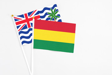 Bolivia and British Indian Ocean Territory stick flags on white background. High quality fabric, miniature national flag. Peaceful global concept.White floor for copy space.