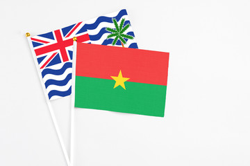 Burkina Faso and British Indian Ocean Territory stick flags on white background. High quality fabric, miniature national flag. Peaceful global concept.White floor for copy space.