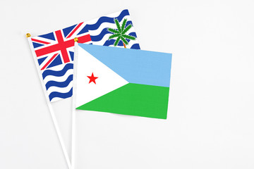 Djibouti and British Indian Ocean Territory stick flags on white background. High quality fabric, miniature national flag. Peaceful global concept.White floor for copy space.