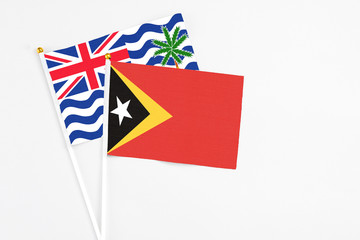 East Timor and British Indian Ocean Territory stick flags on white background. High quality fabric, miniature national flag. Peaceful global concept.White floor for copy space.