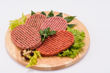 Hamburger di carne di manzo e di maiale su tagliere di legno