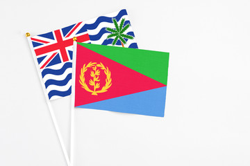 Eritrea and British Indian Ocean Territory stick flags on white background. High quality fabric, miniature national flag. Peaceful global concept.White floor for copy space.